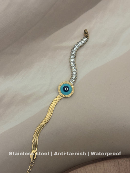stainless steel bracelet features a bold gold chain with a mesmerizing blue & black evil eye charm