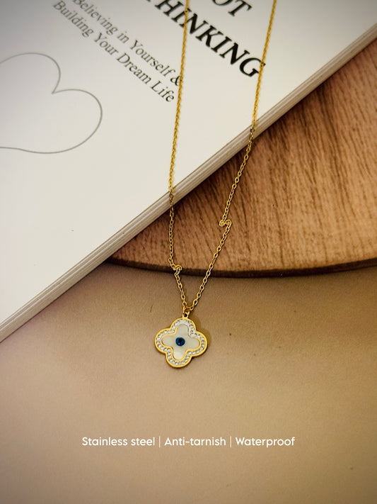 Golden clover charm with white enamel & a sparkling evil eye center