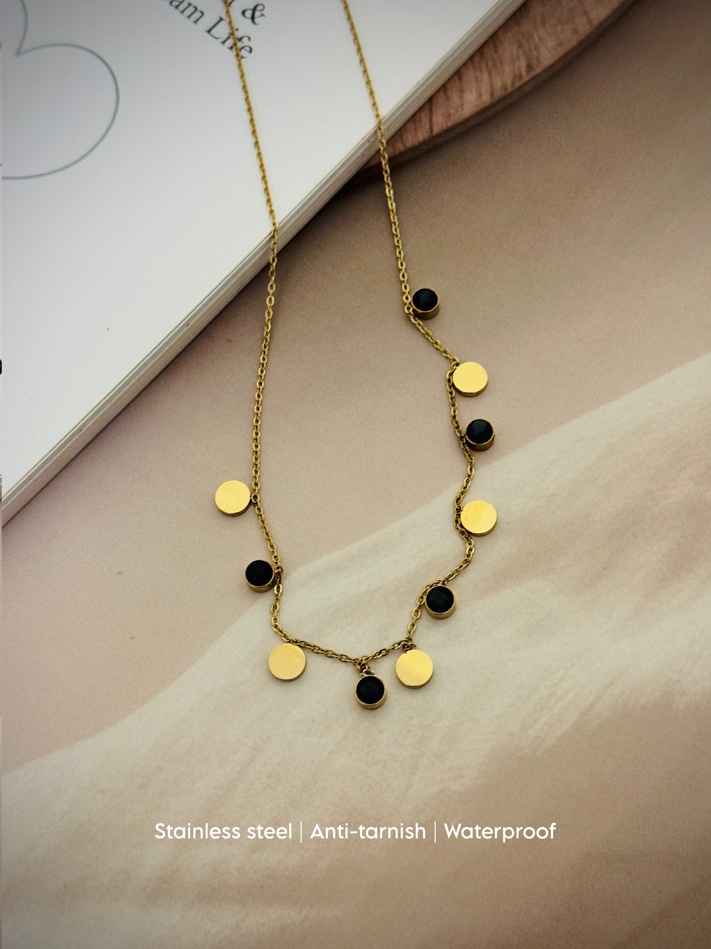 sleek gold chain adorned with alternating gold and black discs
