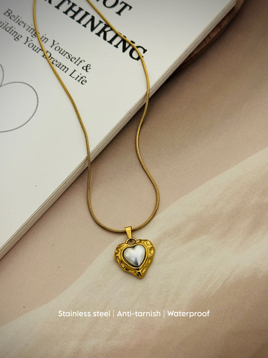 Gold-tone stainless steel necklace with a heart pendant featuring a pearl touch